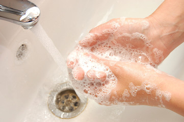 washing hands in sink with soap